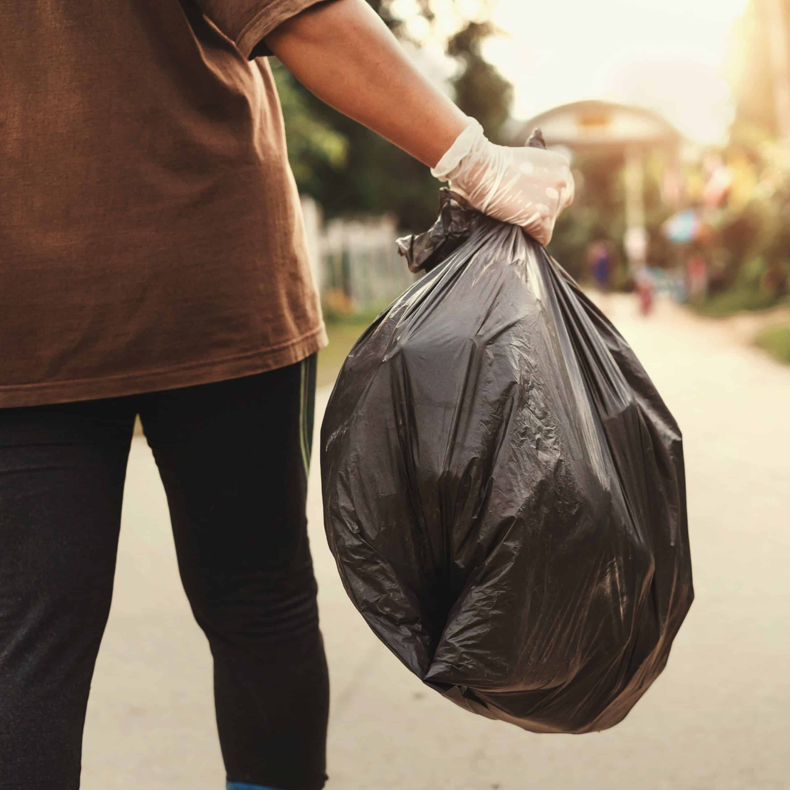 woman hand holding garbage bag for recycle putting in to trash